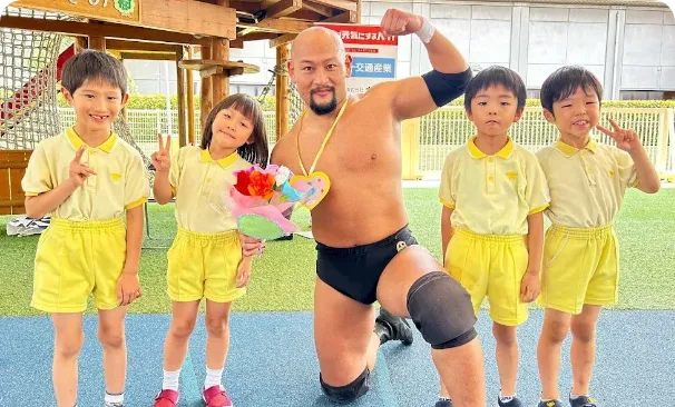 子どもと写真を撮るプロレスラー